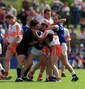 14 May 2000; Referee Brian White attempts to separate Philip Smith of Cavan and Henry Downey of Derry during the Bank of Ireland Ulster Senior Football Championship Quarter-Final match between Cavan and Derry at Breffni Park in Cavan. Photo by David Maher/Sportsfile