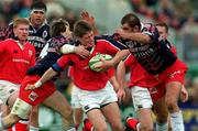 15 April 2000; Ronan O'Gara of Munster is tackled by Christophe Dominici, left, and Darren George of Stade Francais during the Heineken Cup Quarter-Final match between Munster and Stade Francais at Thomond Park in Limerick. Photo by Matt Browne/Sportsfile