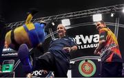 26 March 2015; Phil Taylor kicks a Minion teddy back to the crowd alongside Kim Huybrechts during the Betway Premier League Darts at the 3Arena, Dublin. Picture credit: Stephen McCarthy / SPORTSFILE
