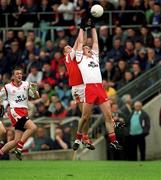 4 June 2000; Colin Holmes of Tyrone goes up for a high ball with Paddy McKeever of Armagh during the Bank of Ireland Ulster Senior Football Championship Quarter-Final match between Tyrone and Armagh at St Tiernach's Park in Clones, Monaghan. Photo by Brendan Moran/Sportsfile