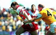 25 June 2000; Johnny McBride of Derry holds off Anto Finnegan of Antrim during the Bank of Ireland Ulster Senior Football Championship Semi-Final match between Antrim and Derry at Casement Park in Belfast, Antrim. Photo by David Maher/Sportsfile