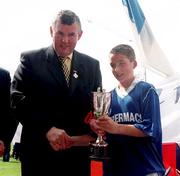 3 July 2000; Tullamore captain Ian Sullivan is presented with the cup by Uachtarán Chumann Lúthchleas Gael Sean McCague after the Feile Peil na nOg Boys U14 Football Division 2 Final match between Tullamore, Offaly v St. Bronagh's in Rostrevor, Down, at Croke Park in Dublin. Photo by Damien Eagers/Sportsfile