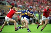 2 July 2000; Eugene O'Neill of Tipperary in action against Fergal Ryan, left and Brian Corcoran of Cork during the Guinness Munster Senior Hurling Championship Final between Cork and Tipperary at Semple Stadium in Thurles, Tipperary. Photo by Brendan Moran/Sportsfile