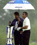 5 July 2000; Seve Ballesteros os Spain shelters from the rain with his caddy Ian Duncan on the 10th green during the Pro Am ahead of the Smurfit European Open Golf Championship at The K Club in Straffan, Kildare. Photo by Matt Browne/Sportsfile