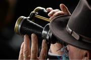 29 April 2015; Brendan Duke, from Dublin, follows the action through World War II era British military binoculars. Punchestown Racecourse, Punchestown, Co. Kildare. Picture credit: Cody Glenn / SPORTSFILE