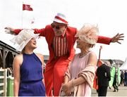 1 May 2015; Laura Ivory of Tipperary, left, and Grace Ormond of Tipperary are greeted by stilt walker Vijaya Bateman from Artastic. Punchestown Racecourse, Punchestown, Co. Kildare. Picture credit: Cody Glenn / SPORTSFILE
