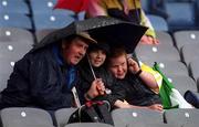 9 July 2000; Offaly supporters shelter from the rain during the Leinster Minor Hurling Championship Final match between Offaly and Dublin at Croke Park in Dublin. Photo by Damien Eagers/Sportsfile