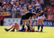 28 May 2000; Brian O'Meara of Tipperary lies injured as team-mate John Leahy and referee Dickie Murphy look on during the Guinness Munster Senior Hurling Quarter-Final match between Tipperary and Waterford at Pairc Ui Chaoimh in Cork. Photo By Brendan Moran/Sportsfile