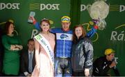 20 May 2015; Ronan McLaughlin after receiving the Cuchulainn statue for the first county rider home in Stage 4 from Miss An Post Rás Siofra Loftus and Alice Schrat following Stage 4 of the 2015 An Post Rás. Bearna - Newport. Photo by Sportsfile