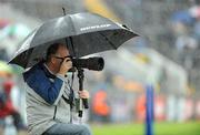 6 July 2008; A photographer takes shelter from the rain during the game. GAA Football Munster Senior Championship Final, Kerry v Cork, Pairc Ui Chaoimh, Cork. Picture credit: Stephen McCarthy / SPORTSFILE