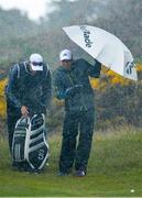28 May 2015; Sergio Garcia, Spain, and his caddy shelter themselves as they consider their options at the 3rd green during a heavy rain shower. Dubai Duty Free Irish Open Golf Championship 2015, Day 1. Royal County Down Golf Club, Co. Down. Picture credit: Brendan Moran / SPORTSFILE