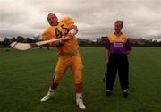 Pittsburgh Steelers Defensive Tackle Frank Messmer demonstrates his hurling skills to Tom Dempsey Wexford Hurler during a promotional photo call  at Belfield yesterday for Sunday's Budweiser American Bowl. American Football.