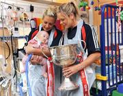 29 September 2008; Cork's Bride Stack, left, and Angela Walsh with 18 week old Laura May Cahill, from Rockchapel, Co. Cork, and the Brendan Martin Cup during a visit to Our Lady's Hospital for Sick Chidren in Crumlin. Crumlin, Co. Dublin. Picture credit: Pat Murphy / SPORTSFILE