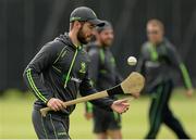10 July 2015; Andrew Balbirnie, Ireland, tries his hand at hurling, the national field sport of Ireland, during the warm up. ICC World Twenty20 Qualifier 2015, Ireland v Namibia. Stormont, Belfast. Picture credit: Oliver McVeigh / ICC / SPORTSFILE