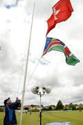 19 July 2015; Dermot Gunn, Clontarf Cricket Club ex-president, raises the flags of Hong Kong and Namibia before the match. ICC World Twenty20 Qualifier 2015, Hong Kong v Namibia. Clontarf, Dublin. Picture credit: Cody Glenn / ICC / SPORTSFILE