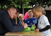 22 July 2015; Leinster rugby players Colm O'Shea and Gavin Thornbury visited the Bank of Ireland Summer Camp at Seapoint RFC to meet with young players. Pictured is Gavin Thornbury signing a boot for a participant. Seapoint RFC, Killiney, Co. Dublin. Picture credit: Sam Barnes / SPORTSFILE