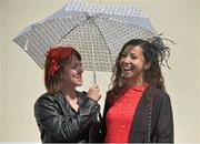 28 July 2015; Laura Sandler, Toronto, Canada, holds the umbrella for friend Echo Foley, Cork City, originally from Toronto, prior to the races. Galway Racing Festival, Ballybrit, Galway. Picture credit: Cody Glenn / SPORTSFILE