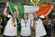 4 August 2015; Team Ireland's John Rowan, left, a member of the bowling team; Laura Reynolds, basketball and Leo O'Brien, golf, all members of the Blue Dolphin Special Olympics Team from Co. Wicklow celebrate together during their homecoming. Team Ireland returns from the Special Olympics World Summer Games. Terminal 2, Dublin Airport. Picture credit: Cody Glenn / SPORTSFILE