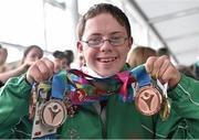 4 August 2015; Team Ireland's Liam Foley, from Killyon, Co. Meath, displays his four medals he won for badminton at Dublin Airport during their homecoming. Team Ireland returns from the Special Olympics World Summer Games. Terminal 2, Dublin Airport. Picture credit: Cody Glenn / SPORTSFILE