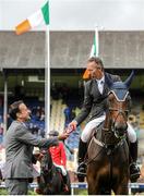 5 August 2015; Dermott Lennon, Ireland, is presented the winning rosette by Leo Varadkar, TD, Minister for Health, after winning the Irish Sports Council Classic on Loughview Lou-Lou during the Discover Ireland Dublin Horse Show 2015. RDS, Ballsbridge, Dublin. Picture credit: Seb Daly / SPORTSFILE