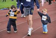 25 December 2008; Four-year-old John Tripp, from Blackrock, Dublin, and his two-year-old brother John set out with their dad Stephen on one of the many Goal Miles at the athletics track in UCD, Belfield, Dublin. This year the event took place at 72 locations around Ireland. Annual Goal Mile, Belfield, University College, Dublin. Picture credit: Ray McManus / SPORTSFILE