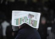 25 January 2009; A race fan uses his newspaper to shelter from a shower. Leopardstown Racecourse, Leopardstown, Co. Dublin. Picture credit: Brian Lawless / SPORTSFILE