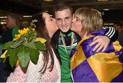 16 August 2015; Ireland's Dean Walsh, welter weight bronze medal winner, is kissed by his cousins Sarah Jane Walsh, left, and Leah Gethings at the Ireland team's homecoming from the EUBC Elite European Boxing Championships. Dublin Airport, Dublin. Picture credit: Cody Glenn / SPORTSFILE