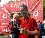23 August 2015;  Mike Nesdale, Vodafone, with his 18 month old son, Eoin, pictured at the finish line after completing the Vodafone Dublin City Triathlon 2015. Phoenix Park, Dublin. Picture credit: David Maher / SPORTSFILE