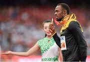 24 August 2015; Usain Bolt of Jamaica poses with his Men's 100m gold medal while being ushered away from the podium area. IAAF World Athletics Championships Beijing 2015 - Day 3, National Stadium, Beijing, China. Picture credit: Stephen McCarthy / SPORTSFILE