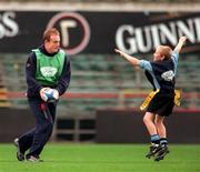 17 October 2000; Ford Motor Company Ltd and the Irish Rugby Football Union (IRFU) today announced a new partnership which will revitalise the way that rugby is introduced into schools and clubs throughout Ireland. This 3 year programme, Ford Tag Rugby, represents the largest investment Ireland by a company focussing exclusively on raising the profile of rugby in the community, amongst both boys and girls from the ages of 7 to 11 and providing equipment and coaching for both players and teachers. Pictured during an exhibition game at the launch with boys from St Michael's College, Ballsbridge, is Leinster and Ireland International Denis Hickie, at Lansdowne Road in Dublin. Photo by Brendan Moran/Sportsfile