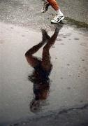 30 October 2000; A runner is reflected in a puddle during the rain soaked 2000 98FM Dublin City Marathon in Dublin. Photo by Brendan Moran/Sportsfile