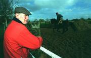 1 December 2000; Horse trainer, Arthur Moore, watches Native Upmanship during a visit to the Rathangan stables in Kildare. Photo by David Maher/Sportsfile