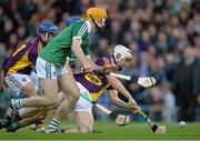 12 September 2015; Cathal Dunbar, Wexford, has a shot on goal despite the attentions of Richie English, Limerick. Bord Gais Energy GAA Hurling All-Ireland U21 Championship Final, Limerick v Wexford, Semple Stadium, Thurles, Co. Tipperary. Picture credit: Brendan Moran / SPORTSFILE
