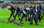 20 September 2015; Members of the Cork 1990 Jubilee Football team race to collect their umbrellas after sitting for a team photograph during their presentation to the crowd before the game. GAA Football All-Ireland Senior Championship Final, Dublin v Kerry, Croke Park, Dublin. Picture credit: Piaras Ó Mídheach / SPORTSFILE