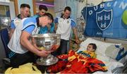 21 September 2015; Dublin's Eric Lowndes hands the Sam Maguire cup to 5 year-old Donegal supporter Declan Meehan, from Letterkenny, during a visit from the GAA Football All-Ireland Champions Dublin to Temple Street Children’s Hospital. Temple Street, Dublin. Picture credit: Ramsey Cardy / SPORTSFILE