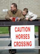 14 April 2009; Sean Yourell, age 9, from Ashbourne, Co. Meath, sneaks a look at his father John's race card ahead of the Weatherbys Ireland GSB Hurdle. Grand National Festival, Fairyhouse Racecourse, Ratoath, Co. Meath. Picture credit: Brian Lawless / SPORTSFILE