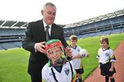 21 April 2009; GAA President Christy Cooney places a helmet on Sean McKee, age 7, from Kilkenny, as Tom Kavanagh, age 6, and Martha Kavanagh, age 5, both from Arklow, Co. Wicklow, look on during the launch of the 2009 VHI GAA Cúl Camps. Now in its fourth year, the VHI GAA Cul Camps is a nationally co-ordinated programme which aims to encourage primary school children between the ages of 7 and 13, to learn and develop sporting and life-skills by participating in Gaelic games, in a fun, non-competitive environment. Last year over 83,000 children attended the VHI GAA Cúl Camps nationwide. Croke Park, Dublin. Picture credit: David Maher / SPORTSFILE