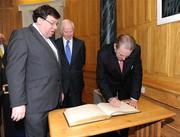 20 May 2009; President of the International Olympic Committee Dr. Jacques Rogge signs the visitors book in the company of An Taoiseach Brian Cowen TD and Pat Hickey, President of the Olympic Council of Ireland, during a courtesy call at Government Buildings. Government Buildings, Dublin. Picture credit: Brendan Moran / SPORTSFILE
