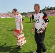 31 May 2009; Tyrone Captain, Brian Dooher, acting as water carrier, comes off the field for the start of the game along with assistant manager Tony Donnelly. Ulster GAA Football Senior Championship Quarter-Final, Tyrone v Armagh, St. Tiernach's Park, Clones, Co.Monaghan. Picture credit: Oliver McVeigh / SPORTSFILE
