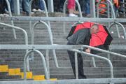 14 June 2009; A supporter shields from a heavy rain shower under an umbrella before the game. GAA Hurling Munster Senior Championship Semi-Final, Limerick v Waterford, Semple Stadium, Thurles, Co. Tipperary. Picture credit: Brendan Moran / SPORTSFILE