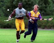 23 July 1997; Chicago Bears line backer Greg Lloyd demonstrates his hurling skills to Wexford Hurler Tom Dempsey at a photo call at UCD in Belfield, Dublin, ahead of the Budweiser American Bowl. Photo by David Maher/Sportsfile