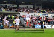 21 June 2009; Tyrone's Ryan McMenamin jumps the bench for the team picture, followed by team-mate Philip Jordan. GAA Football Ulster Senior Championship Semi-Final, Tyrone v Derry, Casement Park, Belfast, Co. Antrim. Picture credit: Daire Brennan / SPORTSFILE