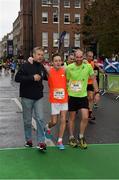 26 October 2015; Martin Kearney, assistant course director, and Mark Leamy, Co. Kildare, assist Dr. Philip Stewart, Co. Dublin near the finish line during the SSE Airtricity Dublin Marathon 2015, Merrion Square, Dublin.Picture credit: Ray McManus / SPORTSFILE