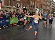 26 October 2015; Kelly McLay, left, from Marathon Tours, USA, and Lyndsey Wakeham, Co. Dublin, jump for joy on their way to finishing the SSE Airtricity Dublin Marathon 2015, Merrion Square, Dublin.Picture credit: Ray McManus / SPORTSFILE