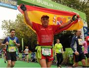 26 October 2015; Juan Pedro Serrano Requena, Spain, holds his his flag aloft after crossing the finish line at the SSE Airtricity Dublin Marathon 2015, Merrion Square, Dublin. Picture credit: Seb Daly / SPORTSFILE