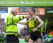 26 October 2015; Sean Hehir in congratulated by race Director Jim Aughney after crossing the finish line at the SSE Airtricity Dublin Marathon 2015, Merrion Square, Dublin. Picture credit: Seb Daly / SPORTSFILE