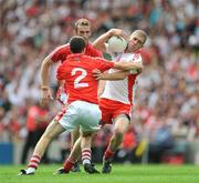 23 August 2009; Kevin Hughes, Tyrone, is tackled by Nicholas Murphy and Ray Carey, Cork. GAA Football All-Ireland Senior Championship Semi-Final, Tyrone v Cork, Croke Park, Dublin. Picture credit: Ray McManus / SPORTSFILE