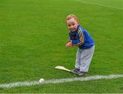 25 June 2015; Two year old Killian Buckley, from Borrisoleigh, Tipperary, warms his hands before taking a 'line ball' as he plays on the pitch before the game. 2015 Electric Ireland Munster GAA Hurling Minor Championship, Clare v Tipperary. Semple Stadium, Thurles, Co. Tipperary. Picture credit: Ray McManus / SPORTSFILE