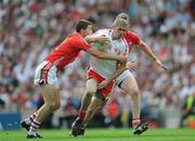 23 August 2009; Kevin Hughes, Tyrone, is tackled by Nicholas Murphy and Ray Carey, Cork. GAA Football All-Ireland Senior Championship Semi-Final, Tyrone v Cork, Croke Park, Dublin. Picture credit: Ray McManus / SPORTSFILE