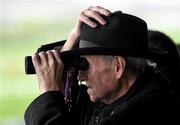 28 December 2015; A racegoer, holds his hat in the strong wind, as he watches the At Races Maiden Hurdle. Leopardstown Christmas Racing Festival, Leopardstown Racecourse, Dublin. Picture credit: Ray McManus / SPORTSFILE